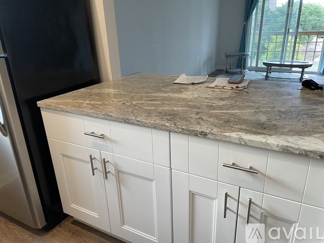 A kitchen with white cabinets and a granite countertop.