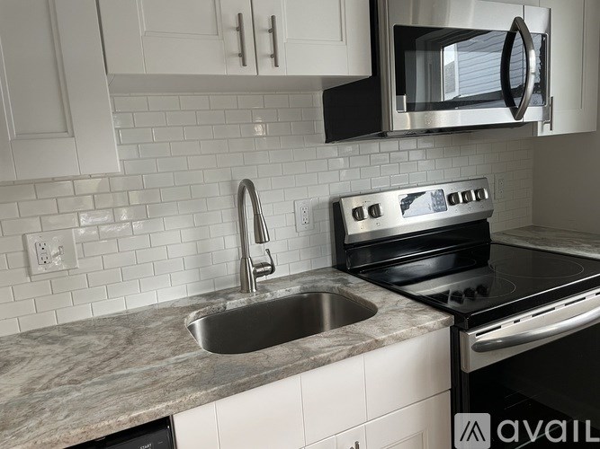 A modern kitchen with a stainless steel oven and a marble countertop.
