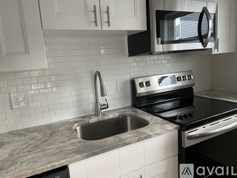 A modern kitchen with a stainless steel oven and a marble countertop.