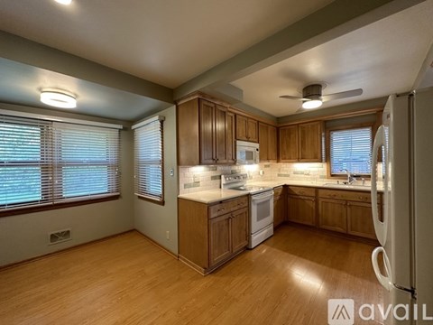 A kitchen with wooden cabinets and a white refrigerator.
