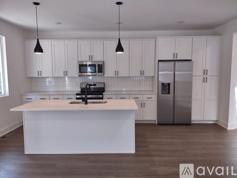 A modern kitchen with white cabinets and a central island.