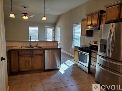 A kitchen with wooden cabinets and stainless steel appliances.