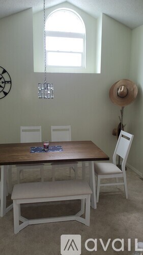 A dining room with a wooden table and chairs.