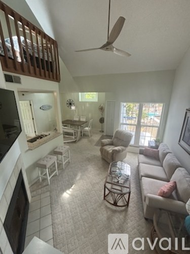 A living room with a white couch and a ceiling fan.