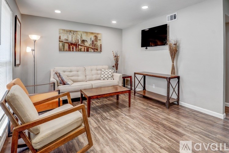 A living room with a white couch, wooden armchair, and a wooden coffee table.