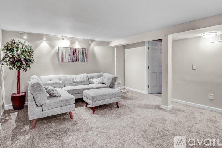 A living room with a grey sofa and a grey ottoman.
