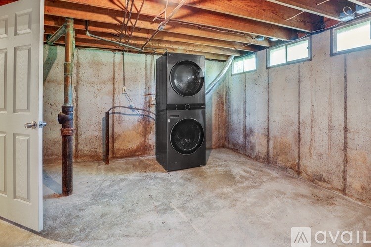 A black speaker stands in a room with a white door and a window.