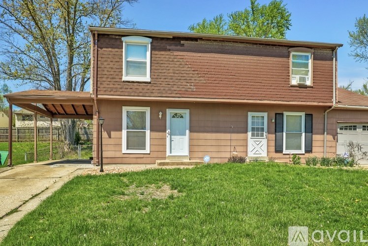 A house with a brown roof and a blue door is for sale.
