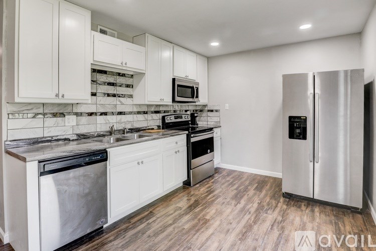 A kitchen with white cabinets and stainless steel appliances.