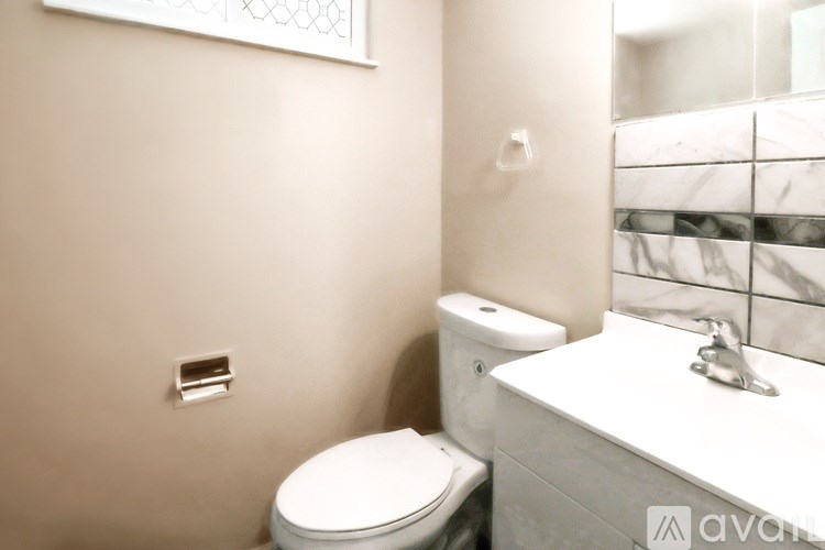 A white toilet sits next to a sink in a bathroom.