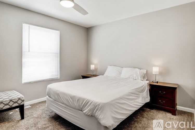 A bedroom with a bed, nightstand, and window.