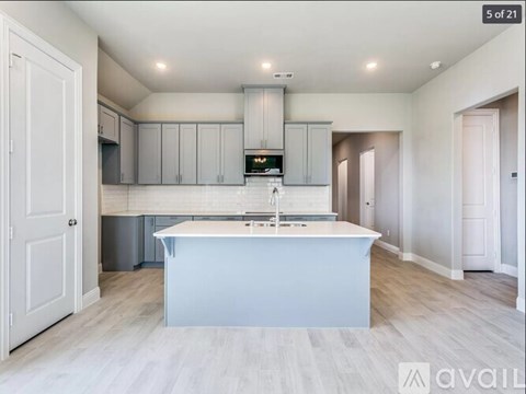 A kitchen with a white island in the middle of the room.