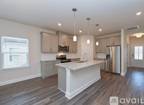 A modern kitchen with a center island and stainless steel appliances.