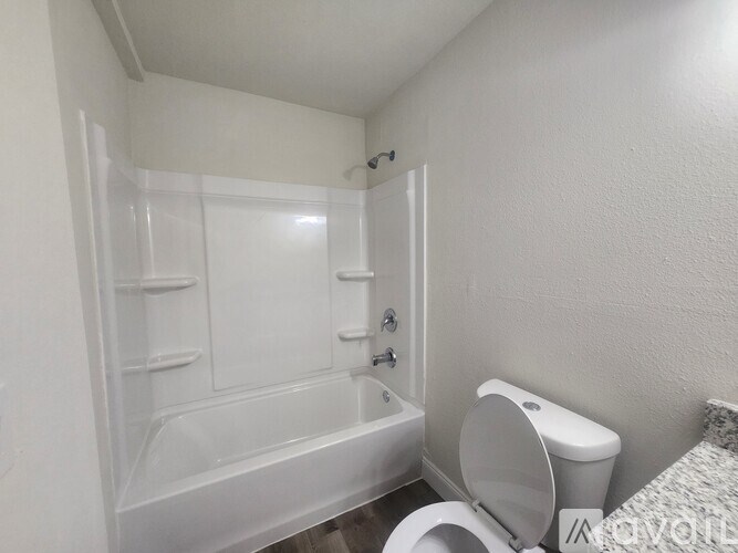 A white bathroom with a toilet, sink, and bathtub.