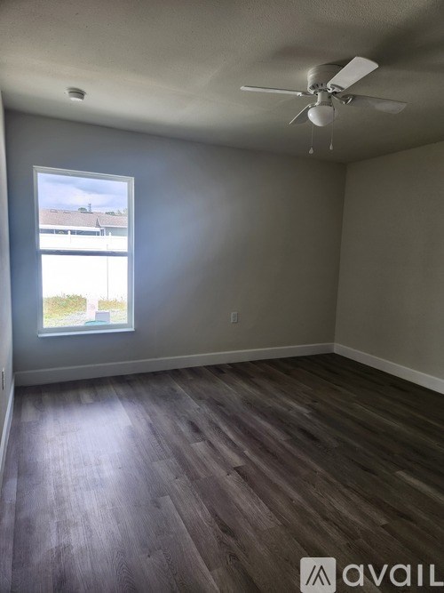 A room with a ceiling fan and a window.
