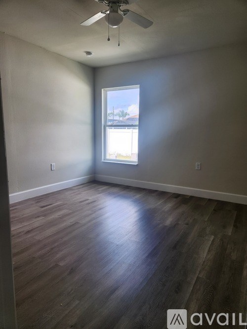 A room with wooden flooring and a ceiling fan.