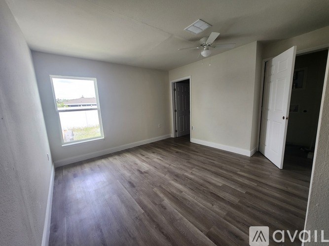 A room with wooden flooring and a window.