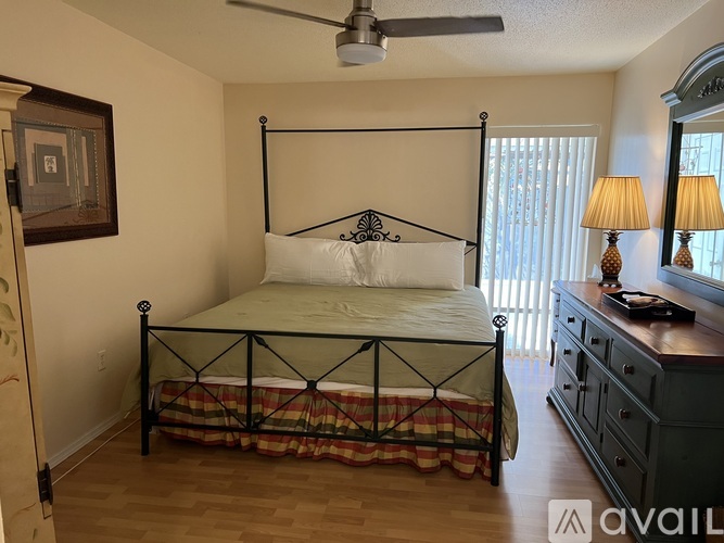 A bedroom with a four poster bed and a dresser.