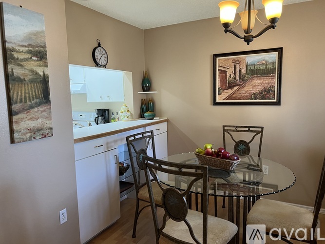 A kitchen with a table and chairs and a painting on the wall.