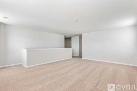 A spacious room with a carpeted floor and a door in the background.