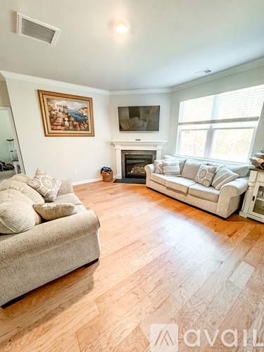 A living room with a couch, a fireplace, and a painting on the wall.