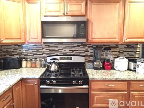 A kitchen with wooden cabinets and a black stove top.