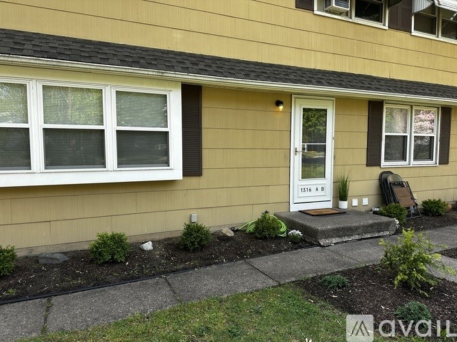 A house with a white door and windows is for sale.