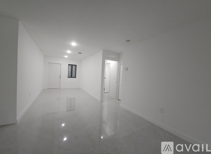 A spacious, empty room with a marble floor and white walls.