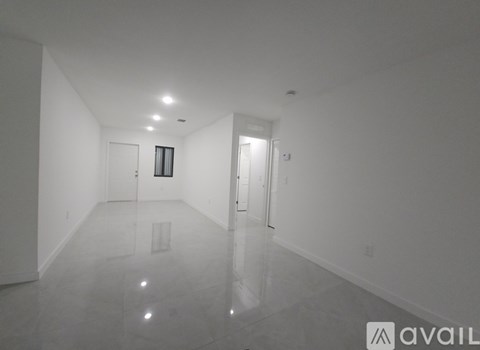 A spacious, empty room with a marble floor and white walls.