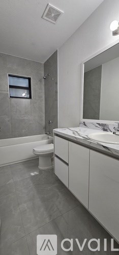 A bathroom with a toilet, sink, and shower.