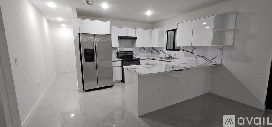 A kitchen with a marble countertop and a refrigerator.