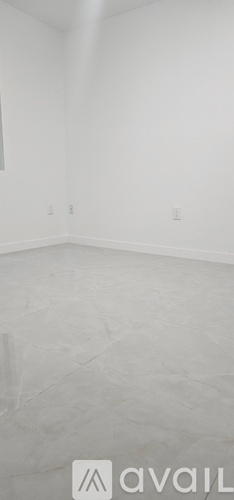 A room with white walls and a grey floor.