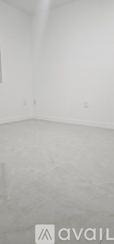 A room with white walls and a grey floor.
