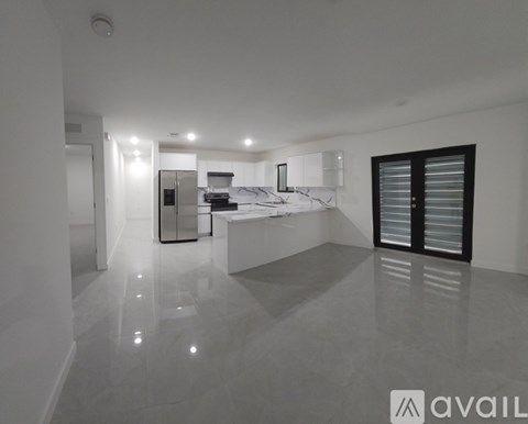 A modern kitchen with a marble countertop and stainless steel appliances.