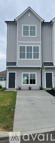A two-story house with a grey exterior and a white window.