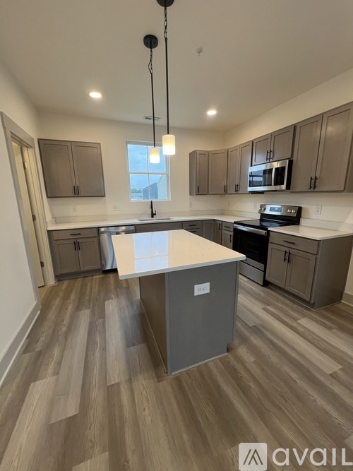 A kitchen with wooden floors and a large island in the middle.