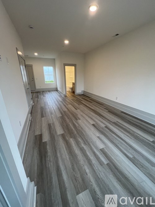 A room with wooden flooring and white walls.
