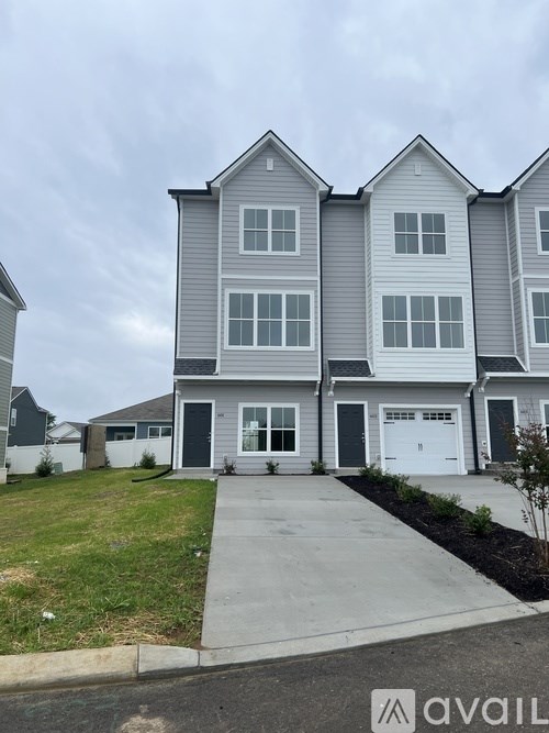 A two-story house with a grey and white exterior and a white garage door.