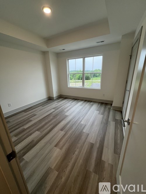 A room with wooden flooring and a large window.