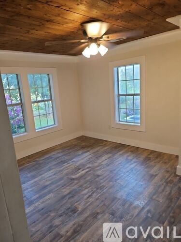 A room with wooden floors and a ceiling fan.