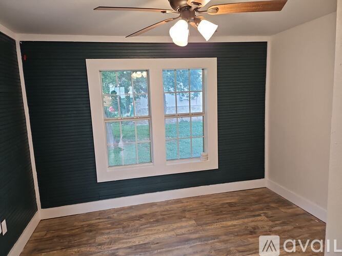 A room with a window and a ceiling fan.