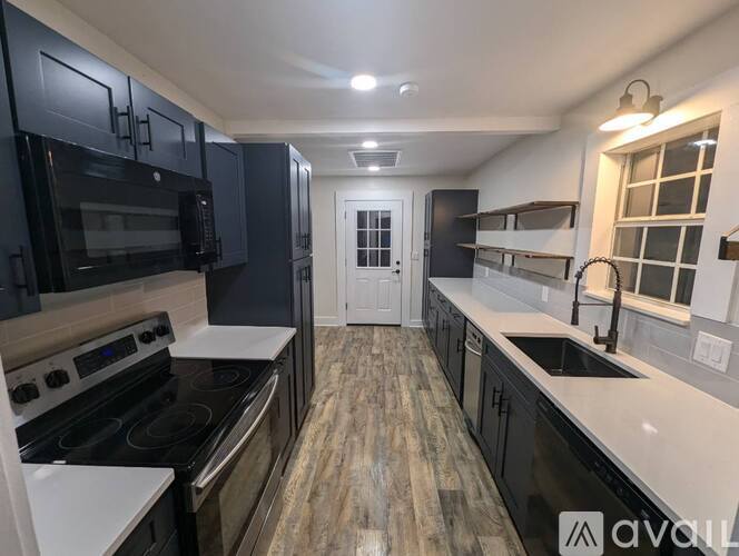 A kitchen with black cabinets and a white countertop.