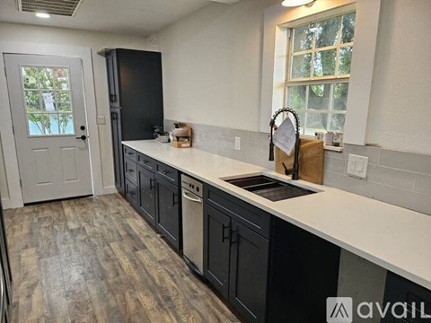 A kitchen with black cabinets and a white countertop.