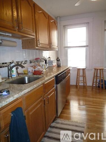A kitchen with wooden cabinets and a marble countertop.