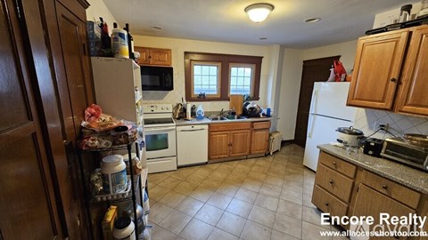A kitchen with a refrigerator, microwave, oven, and dishwasher.