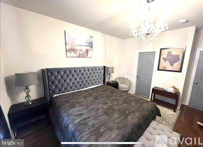 A bedroom with a bed, nightstands, and a painting on the wall.