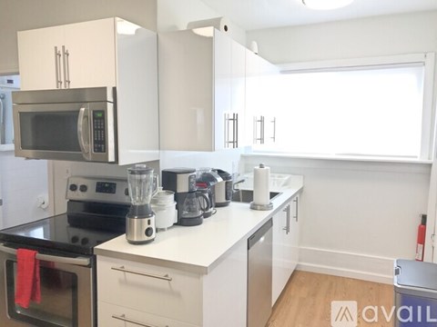 A kitchen with white cabinets and appliances.