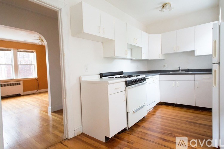 A kitchen with white cabinets and a black stove top oven.