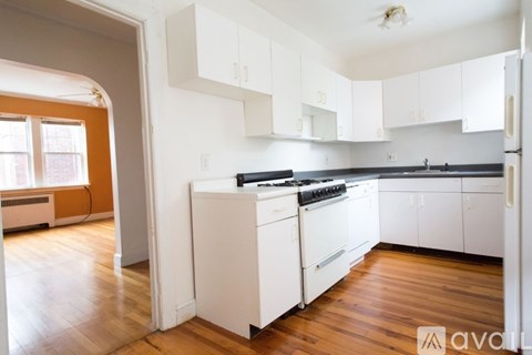 A kitchen with white cabinets and a black stove top oven.