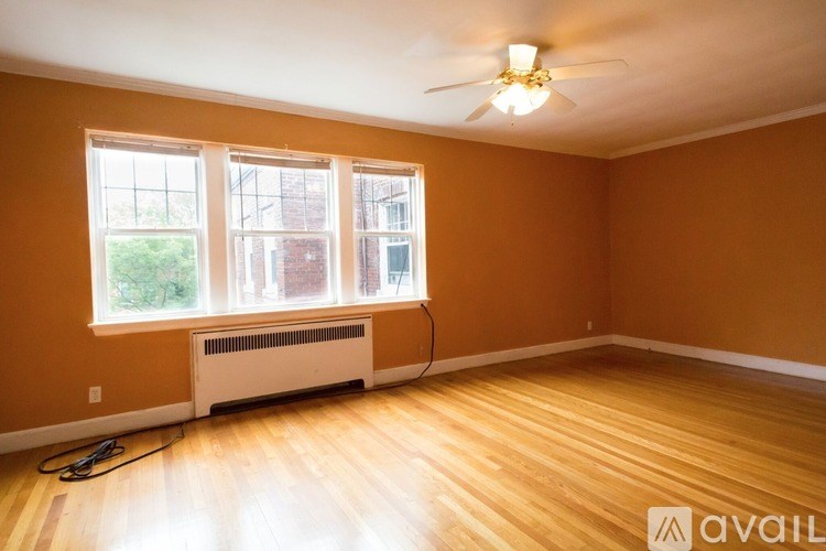 A room with a fan, a window, and a heater.